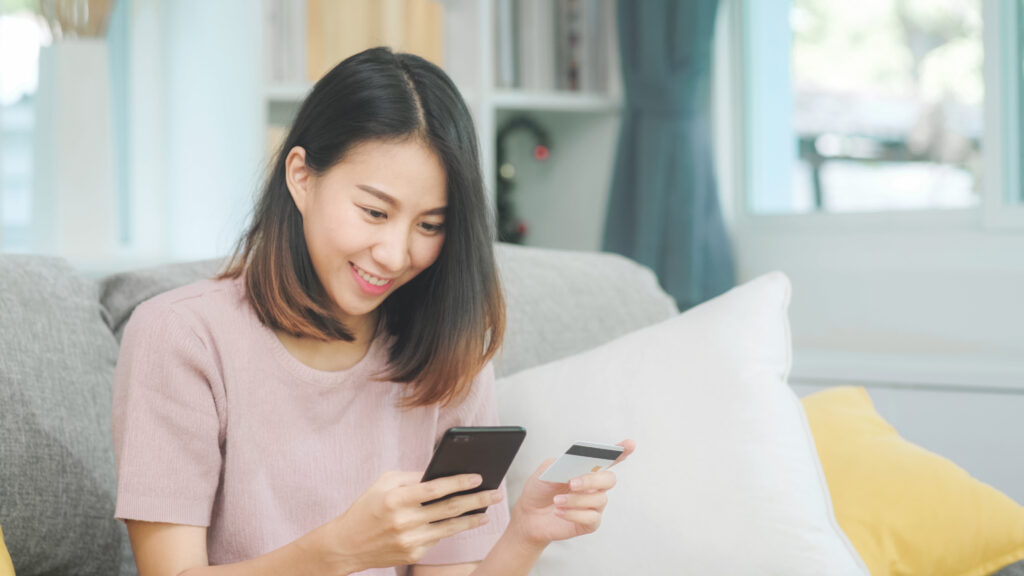 a woman holding her phone and her credit card