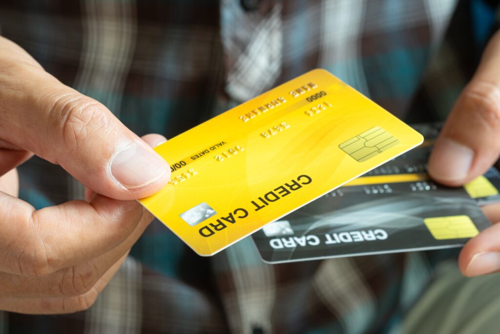 a man holding two credit cards