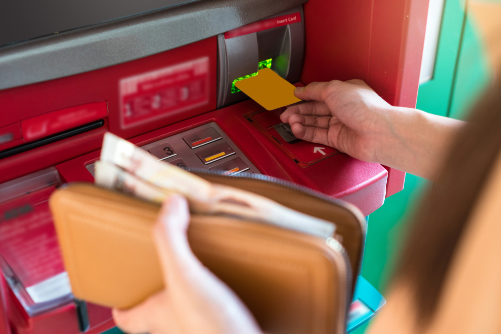a man inserting his credit card in an atm machine