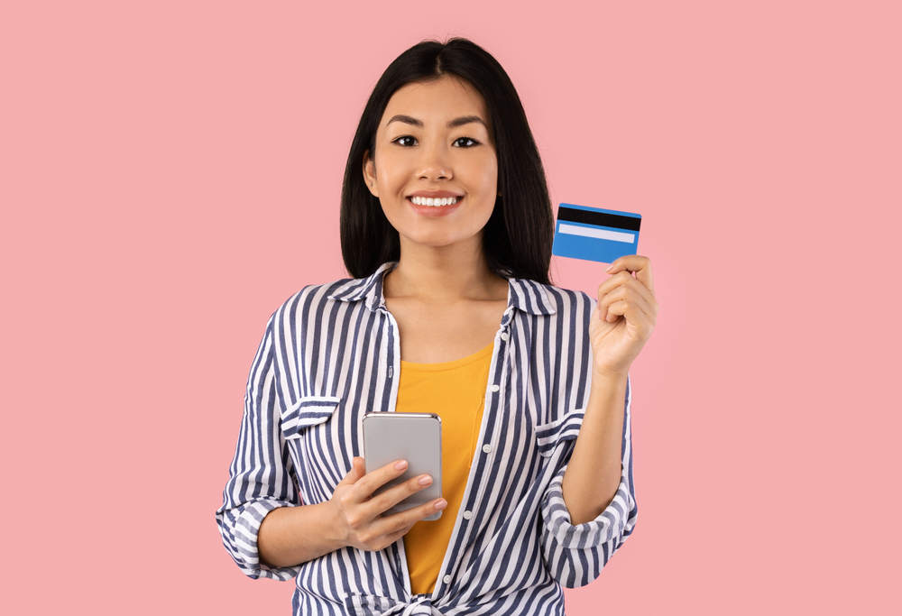 a woman holding her phone and her credit card