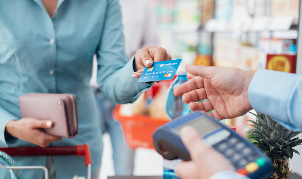 a woman handing out her credit card to pay